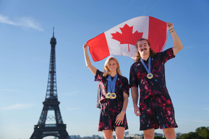 Team Canada’s Summer McIntosh, left, and Ethan Katzberg pose in front of the Eiffel Tower at the 2024 Paris Olympic Games in France on Sunday, August 11, 2024. Photo by Darren Calabrese/© 2024 Canadian Olympic Committee